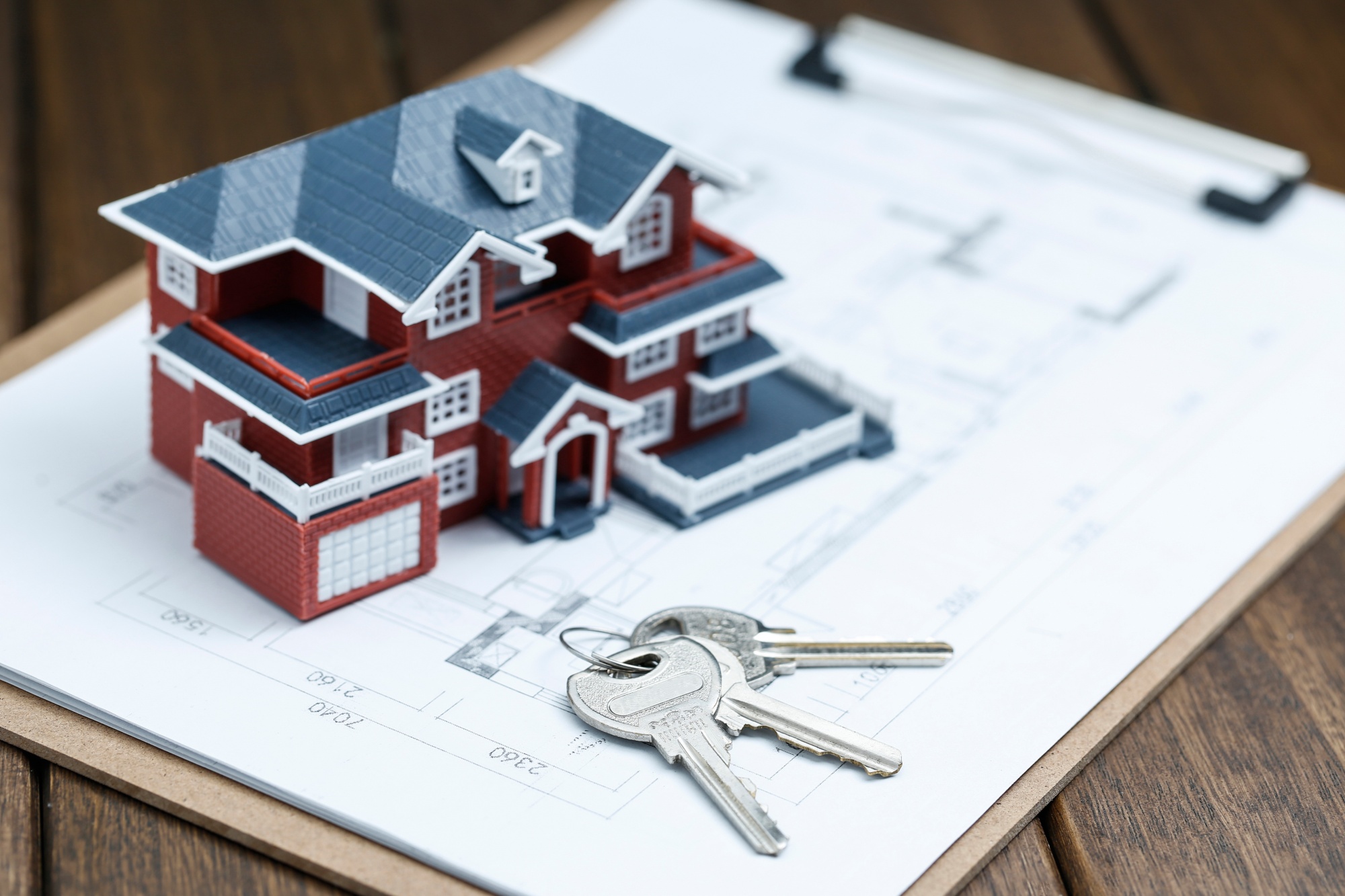 Model house with keys on architectural plans, symbolizing the role of a Top Real Estate Agent in Orange County