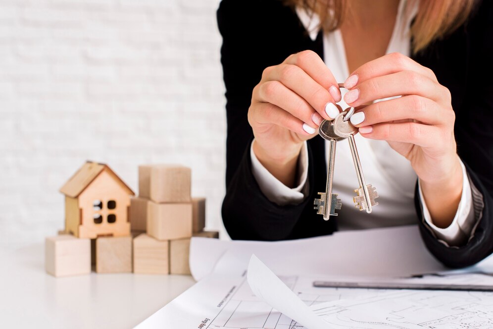 Real estate agent holding keys with property models, representing successful transactions by a Top Real Estate Agent in Irvine