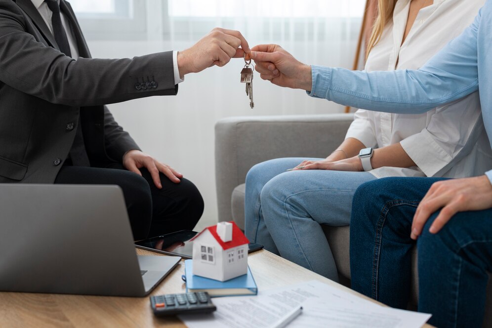 Real estate agent handing house keys to a couple, symbolizing a successful transaction with the Best Real Estate Agent in Newport Beach