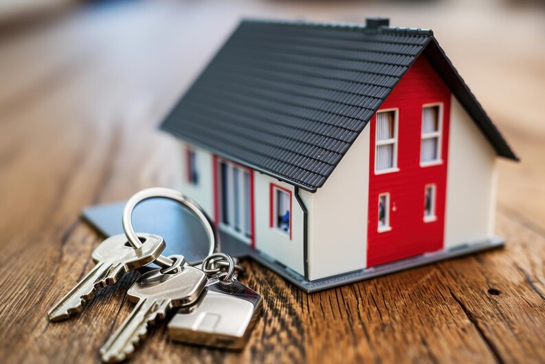 House keys next to a miniature house model - Top real estate agent in Aliso Viejo.