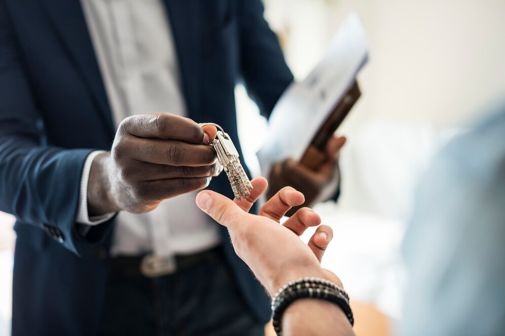 Real estate agent handing over house keys to a client, highlighting a successful transaction by a Top Real Estate Agent in Irvine