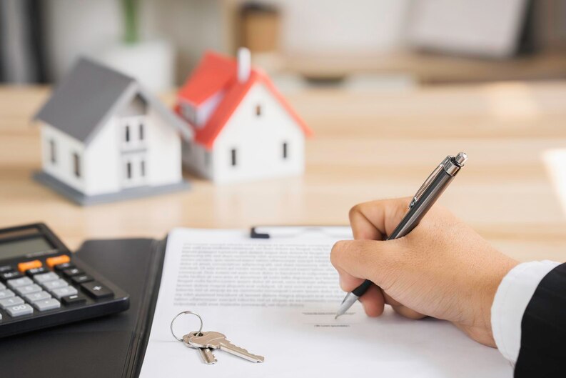 Best real estate agent in Aliso Viejo signing a contract with house models and keys on the desk.