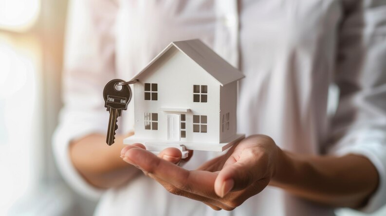 Person holding a model house with key - best real estate agent in Newport Coast